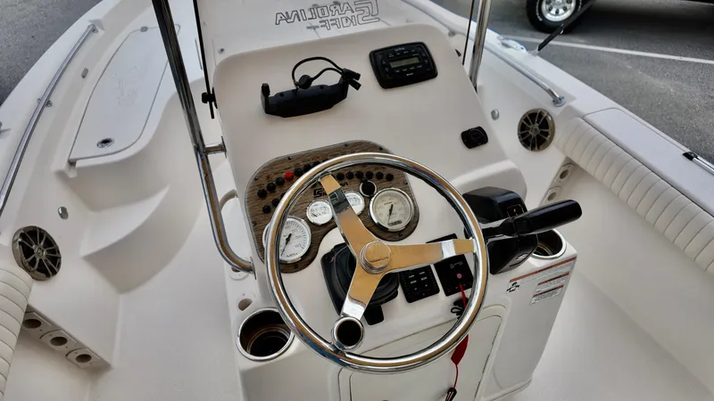 Slide: The Image of 2018 Sea Chaser LX 21 boat dashboard with steering wheel and controls. - 11