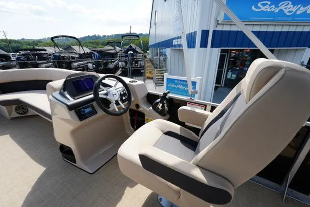 Slide: The Image of 2025 Harris Cruiser 230 boat interior with captain's chair and control panel at marina. - 13