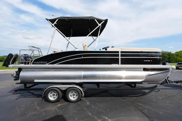 Slide: The Image of 2025 Harris Cruiser 230 pontoon boat on trailer, black and silver design, with canopy. - 5