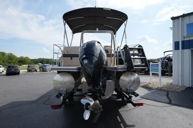 Slide: The Image of 2025 Harris Cruiser 230 pontoon boat with outboard motor, parked on a sunny day. - 7