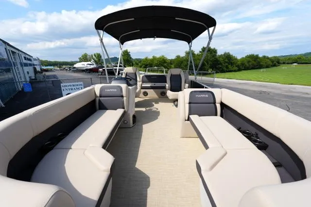 Slide: The Image of 2025 Harris Cruiser 230 pontoon boat with spacious seating and canopy, docked near greenery. - 9