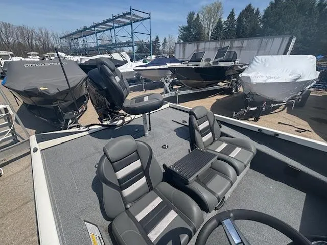 Slide: The Image of 2024 Ranger RT188 boat with gray seating, parked among other boats in a marina. - 10