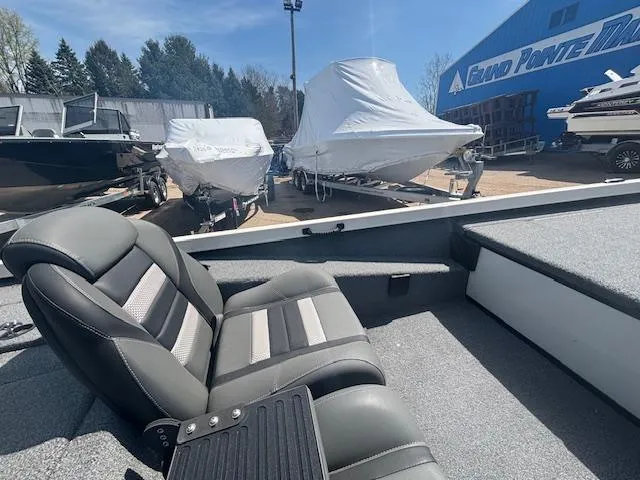 Slide: The Image of 2024 Ranger RT188 boat interior with cushioned seats, parked near covered boats at a dealership. - 16