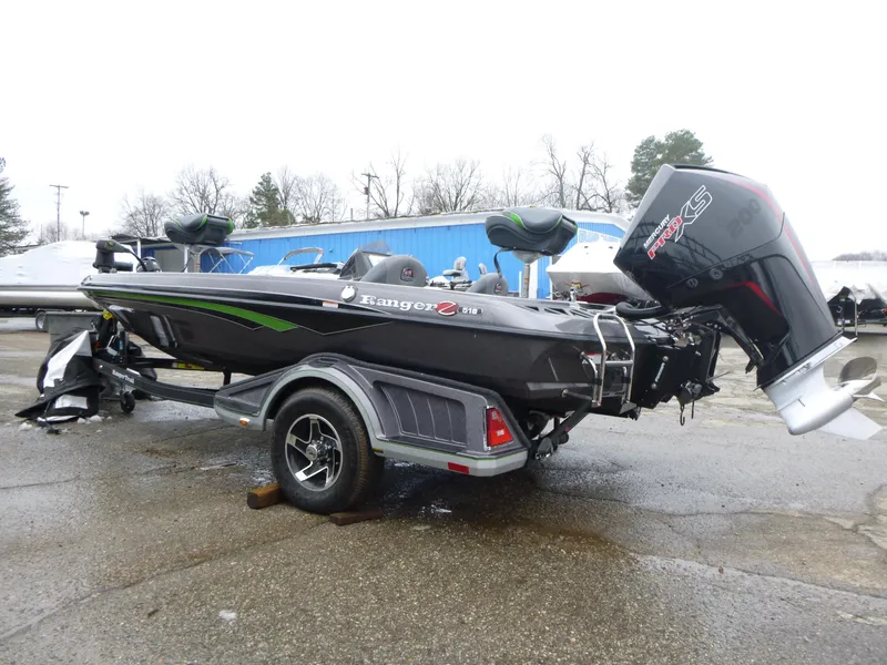 Slide: The Image of 2023 Ranger Z518 boat with trailer, parked outdoors on a rainy day. - 3