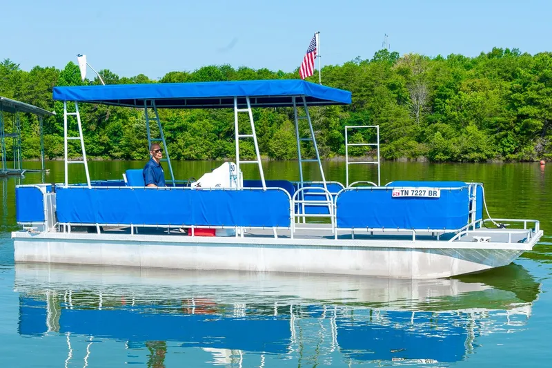 Slide: The Image of Custom Lake Wind 25 x 10 Pontoon boat on a serene lake, 2000 model. - 1