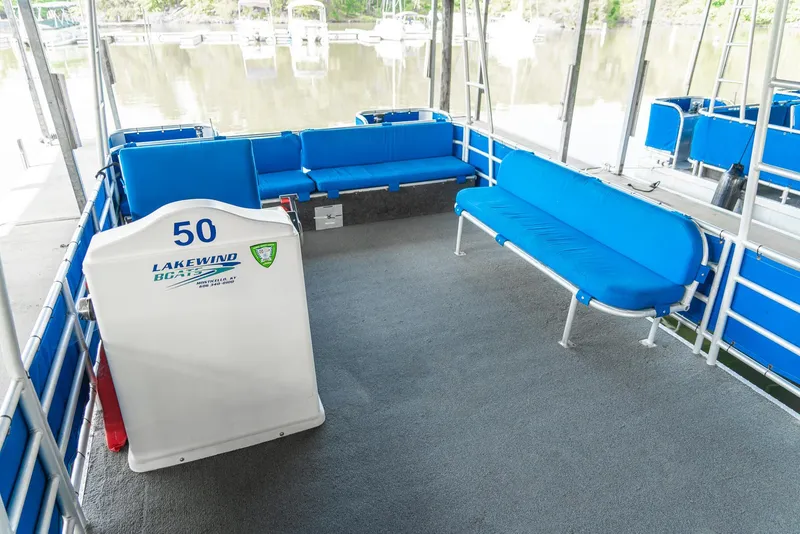 Slide: The Image of Spacious interior of 2000 Custom Lake Wind 25 x 10 Pontoon with blue seating. - 17