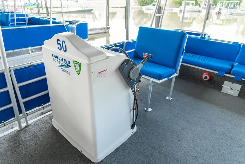 Slide: The Image of Pontoon boat interior with blue seating, steering console, and lake view. - 18