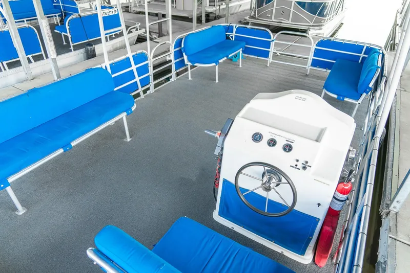 Slide: The Image of Spacious interior of 2000 Custom Lake Wind 25 x 10 Pontoon with blue seating and helm. - 20