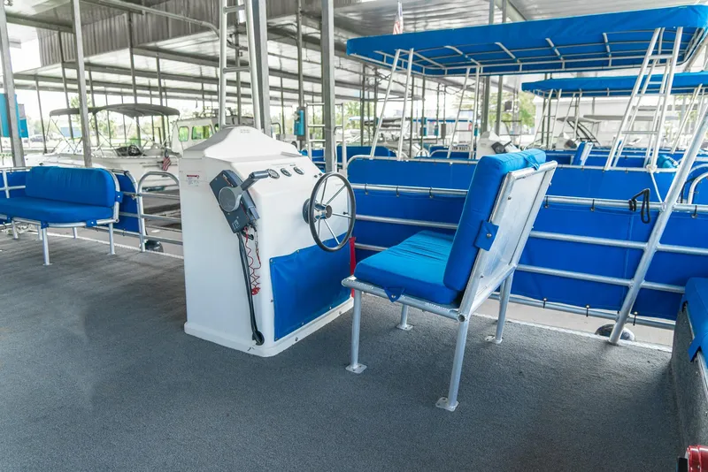 Slide: The Image of Pontoon boat interior with blue seating, steering console, and canopy. Custom Lake Wind 25 x 10, 2000. - 22
