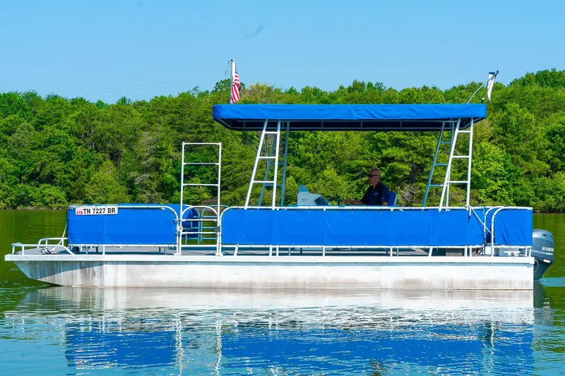 Slide: The Image of Custom Lake Wind 25 x 10 Pontoon, 2000 model, cruising on a serene lake with lush greenery. - 3