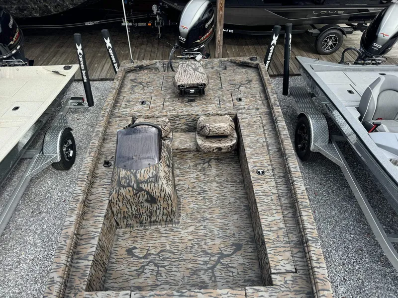 Slide: The Image of 2025 Xpress Xplorer Series XP180 boat with camouflage design, parked on gravel. - 5
