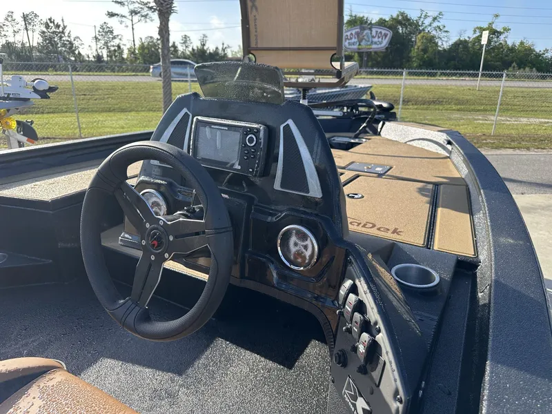 Slide: The Image of 2025 Xpress Hyper-Lift H18 Crappie Model boat dashboard with steering wheel and navigation system. - 10