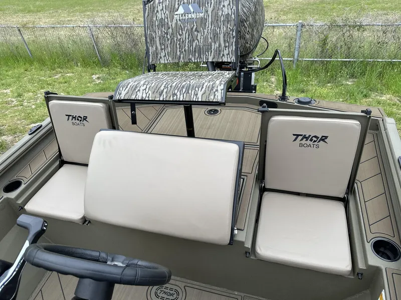 Slide: The Image of 2025 Thor LAKE HAMMER 1900 CC boat interior with beige seats and camo-patterned chair. - 6