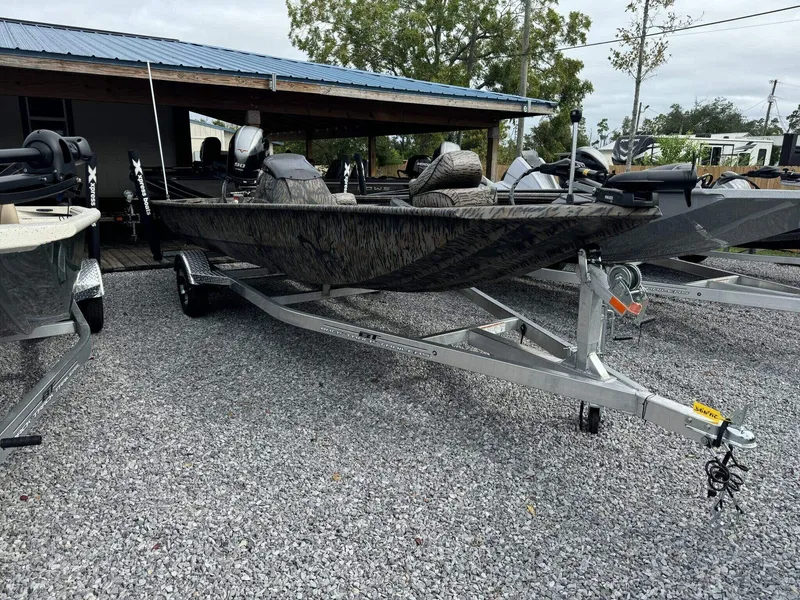 Slide: The Image of 2025 Xpress Xplorer Series XP180 boat on trailer, parked on gravel. - 2