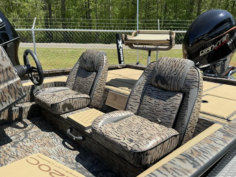 Slide: The Image of 2025 Xpress Hyper-Lift Crappie Series H20 boat with camo seats and powerful engine. - 6