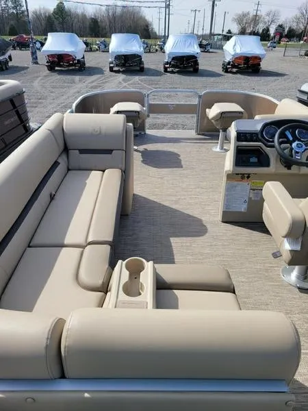 Slide: The Image of 2023 Godfrey Sweetwater SW2286F pontoon boat interior with beige seating and steering console. - 11