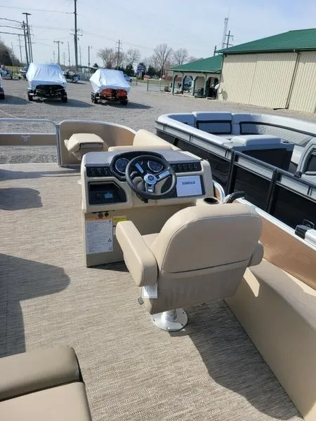 Slide: The Image of 2023 Godfrey Sweetwater SW2286F pontoon boat interior with beige seating and steering console. - 4