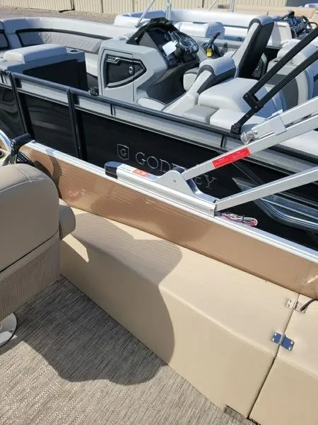 Slide: The Image of 2023 Godfrey Sweetwater SW2286F boat interior with beige seating and modern controls. - 7