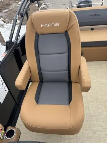 Slide: The Image of 2025 Harris CRUISER 230 SLDH boat seat, tan and gray upholstery, armrests, outdoor setting. - 13
