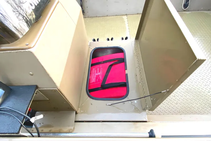 Slide: The Image of Open storage compartment in a 2007 G3 1966 CC boat with red bag inside. - 5