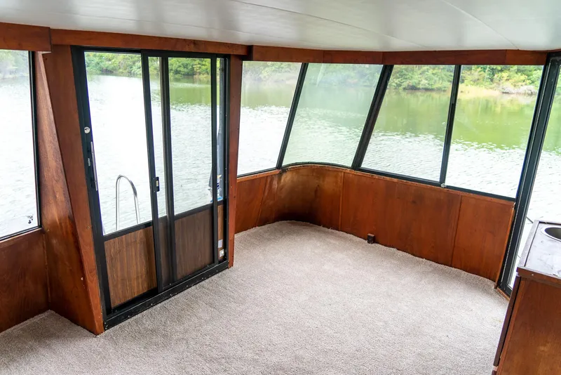 Slide: The Image of Interior of 1985 Bluewater 46 Motor Yacht with large windows and carpeted floor. - 11