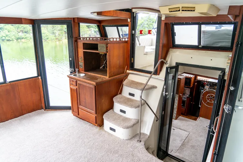 Slide: The Image of Interior of 1985 Bluewater 46 Motor Yacht with wood accents and carpeted stairs. - 12