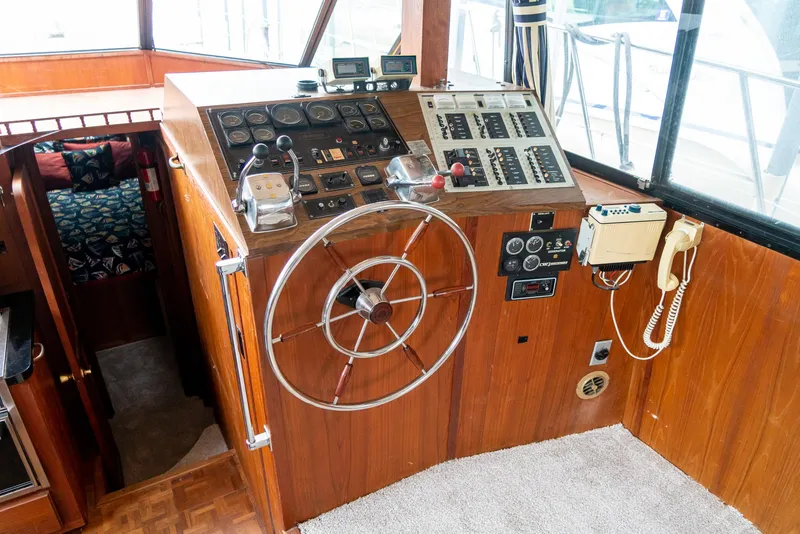 Slide: The Image of 1985 Bluewater 46 Motor Yacht helm with steering wheel and control panels. - 14