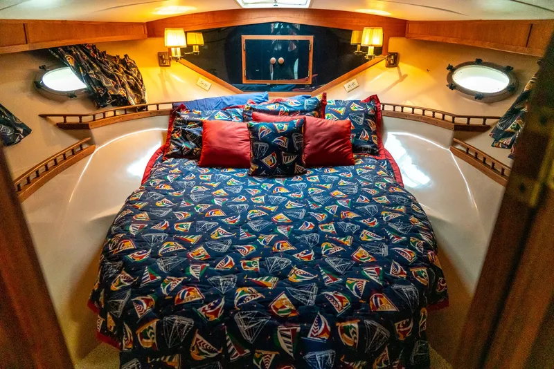 Slide: The Image of Cozy bedroom in 1985 Bluewater 46 Motor Yacht with nautical-themed bedding and warm lighting. - 18