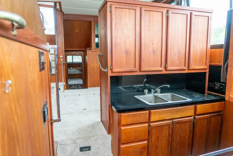 Slide: The Image of Interior of 1985 Bluewater 46 Motor Yacht with wooden cabinetry and dual sink. - 21
