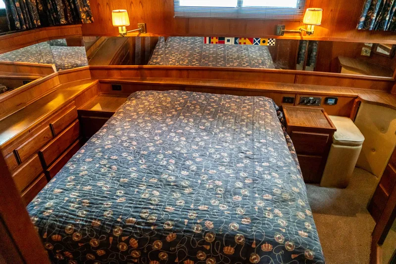 Slide: The Image of Bedroom interior of 1985 Bluewater 46 Motor Yacht with nautical decor and wood paneling. - 23