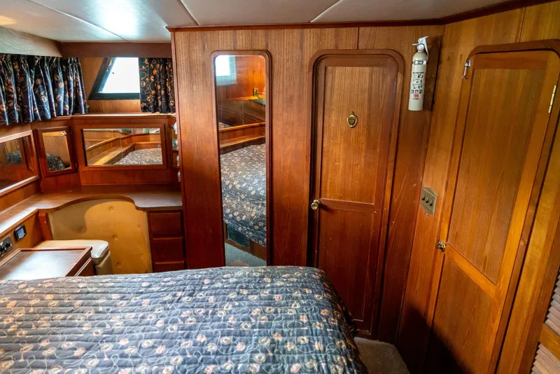 Slide: The Image of Interior of 1985 Bluewater 46 Motor Yacht with wood paneling and cozy bedroom. - 25