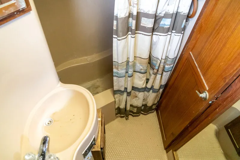 Slide: The Image of 1985 Bluewater 46 Motor Yacht bathroom with sink, shower, and curtain. - 27