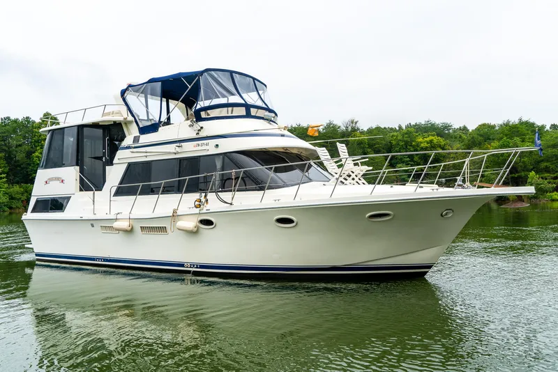 Slide: The Image of 1985 Bluewater 46 Motor Yacht on calm water, featuring sleek design and spacious deck. - 3