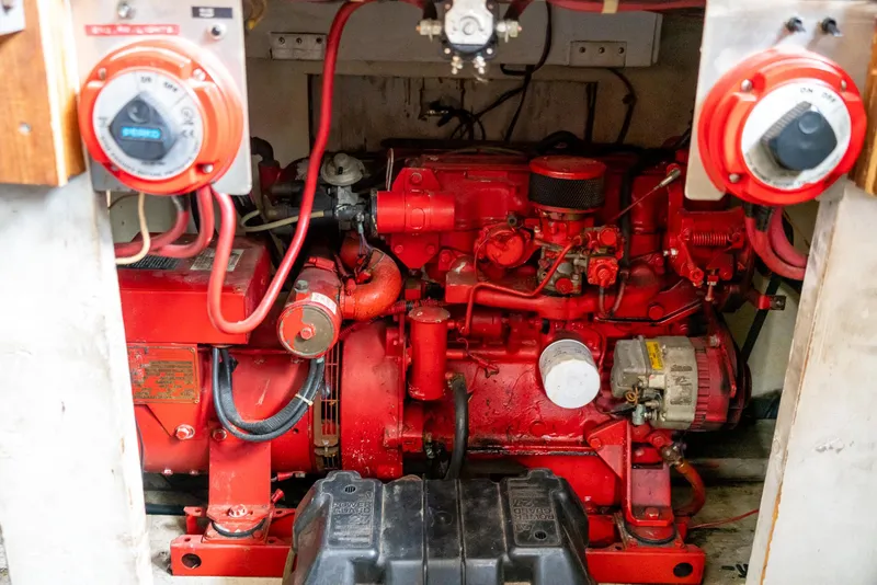 Slide: The Image of Engine room of a 1985 Bluewater 46 Motor Yacht with red machinery and wiring. - 30