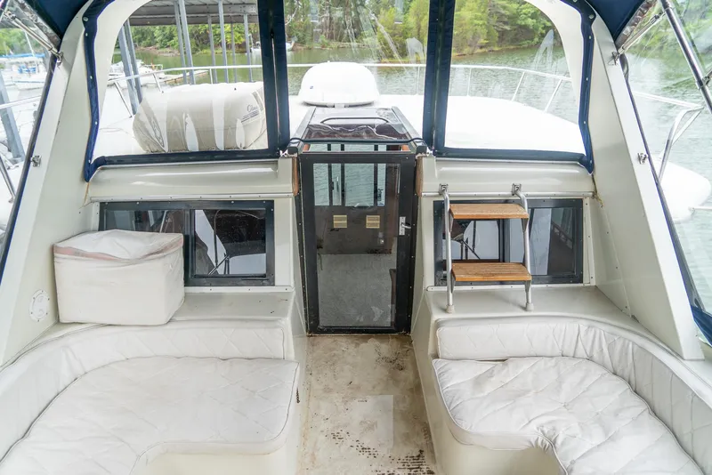 Slide: The Image of 1985 Bluewater 46 Motor Yacht interior with white seating and outdoor view. - 9