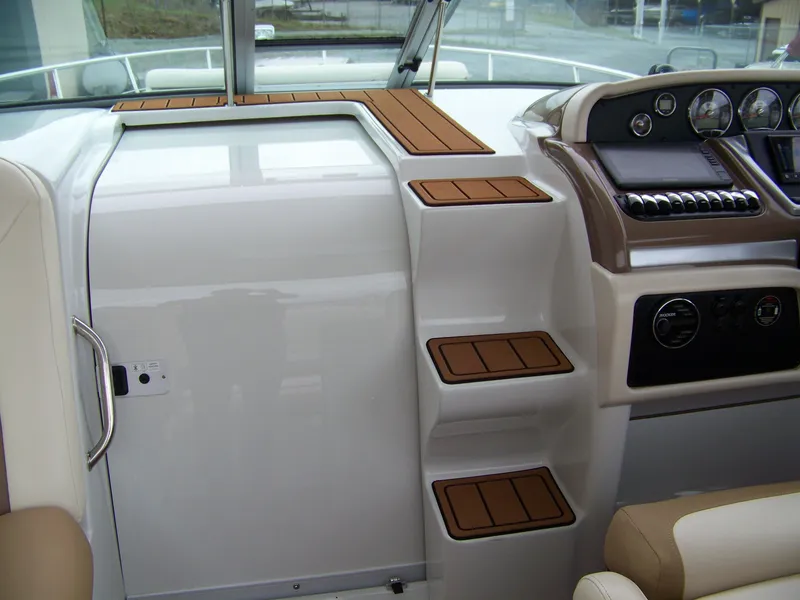 Slide: The Image of 2020 Crownline 350 SY boat interior with sleek dashboard and wooden step accents. - 14