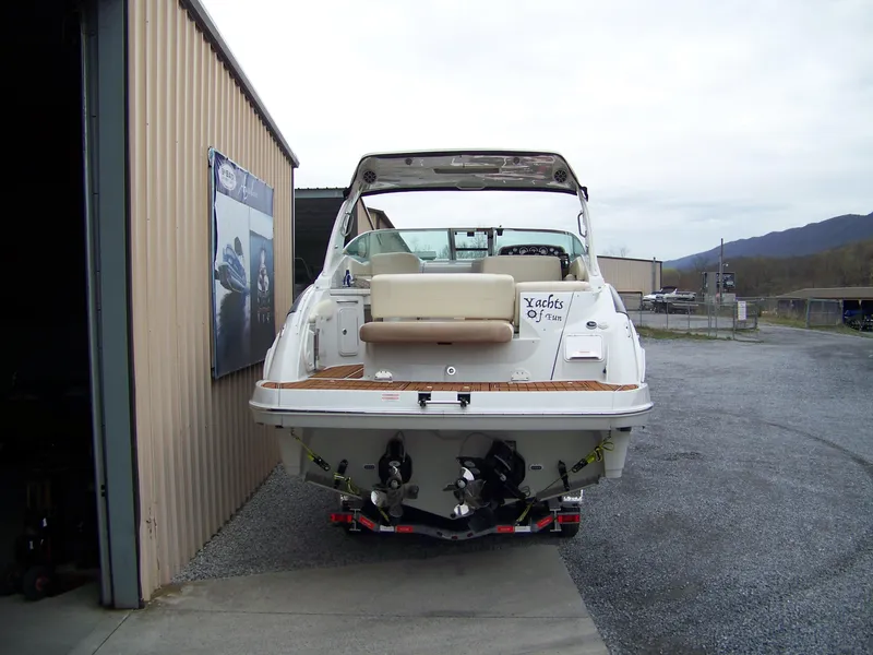 Slide: The Image of 2020 Crownline 350 SY boat docked near a building, rear view. - 2