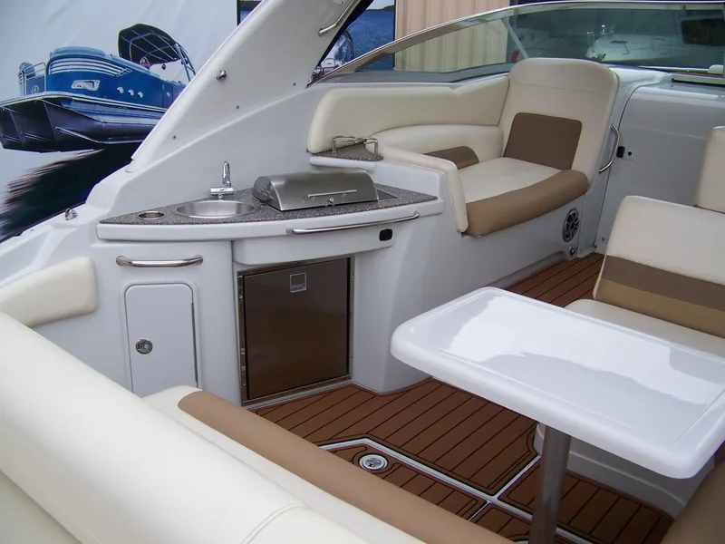 Slide: The Image of 2020 Crownline 350 SY yacht interior with seating, table, and kitchenette. - 7