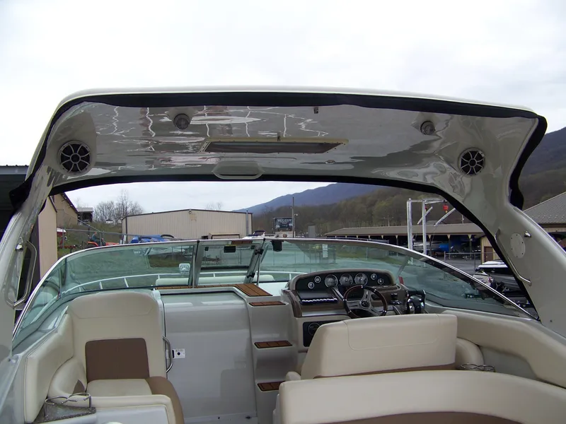 Slide: The Image of 2020 Crownline 350 SY boat interior with dashboard and seating, under a cloudy sky. - 8