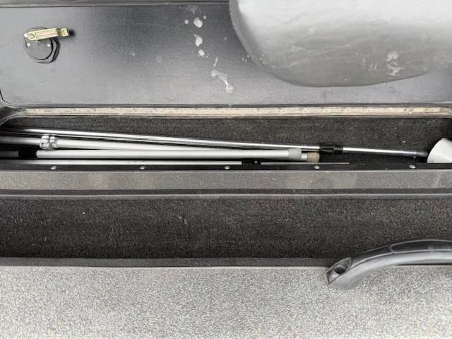 Slide: The Image of Storage compartment in a 2016 Warrior V2090 boat, containing metal poles. - 12
