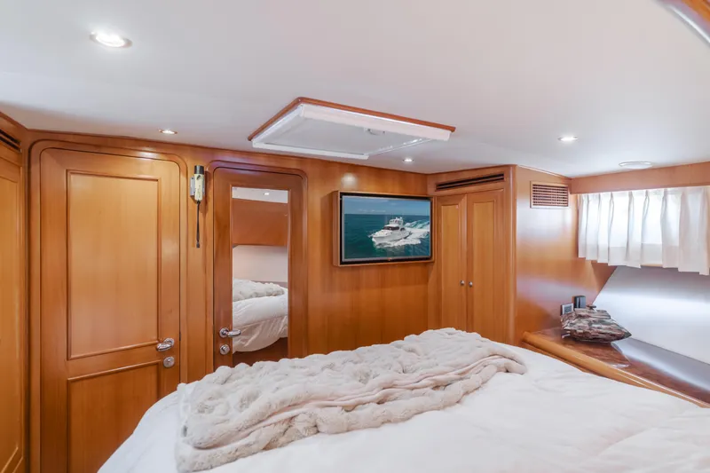Slide: The Image of Luxurious cabin interior of 2005 Ocean Alexander 548 Pilothouse yacht, featuring wood paneling and cozy bedding. - 45