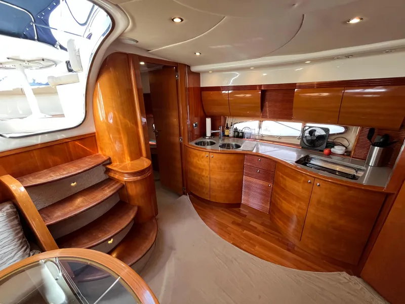 Slide: The Image of Luxurious 2006 Azimut Atlantis yacht interior with elegant wooden cabinetry and modern kitchen amenities. - 21