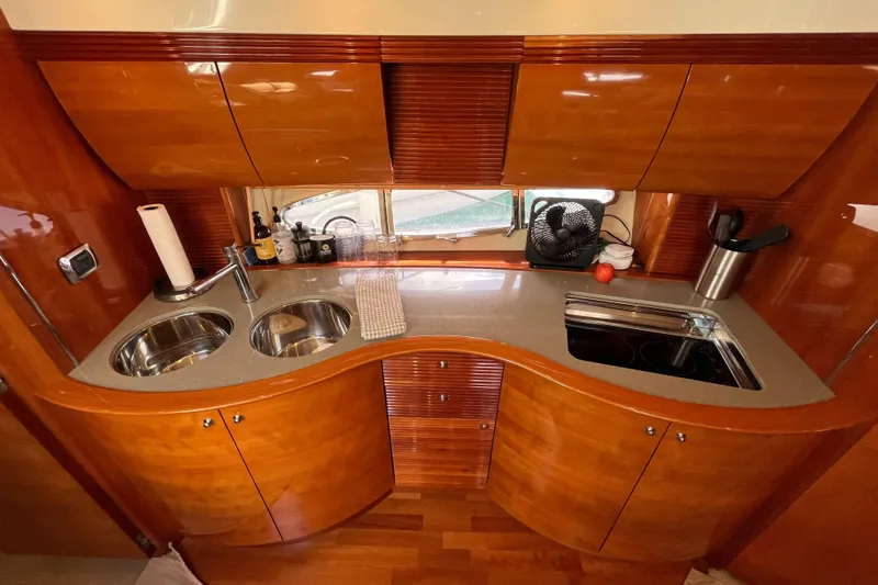 Slide: The Image of Luxurious kitchen interior of a 2006 Azimut Atlantis yacht with wooden cabinetry and modern appliances. - 23