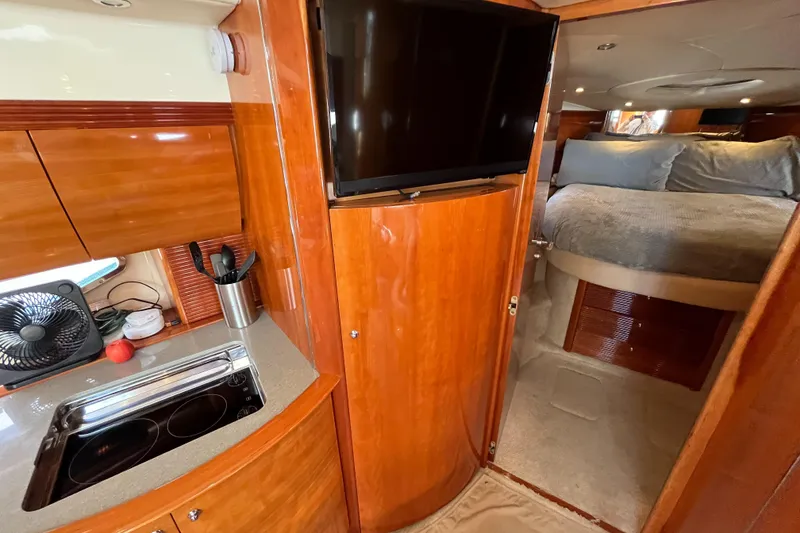Slide: The Image of 2006 Azimut Atlantis yacht interior with kitchen, TV, and cozy bedroom. - 26