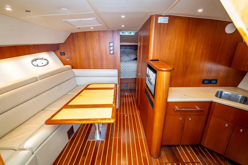 Slide: The Image of 2005 Tiara Yachts 4200 Open interior with wood finish, seating, and kitchenette. - 12