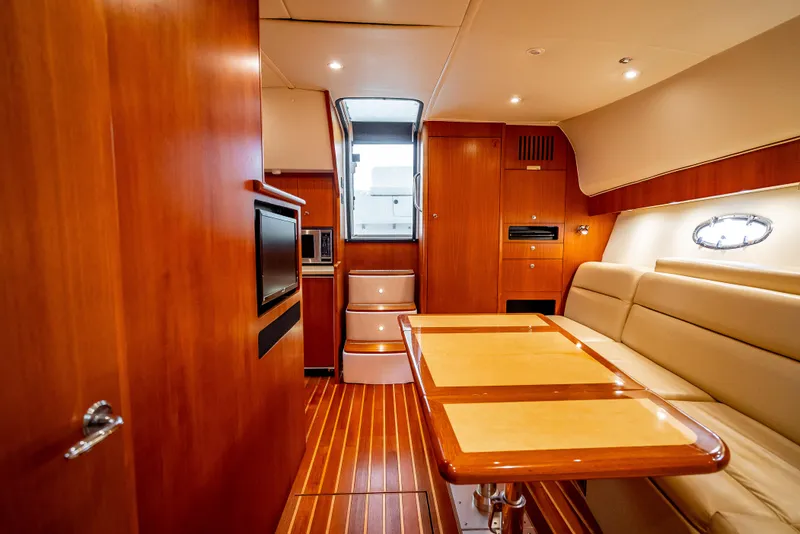 Slide: The Image of 2005 Tiara Yachts 4200 Open interior with wood finish, dining area, and modern amenities. - 13