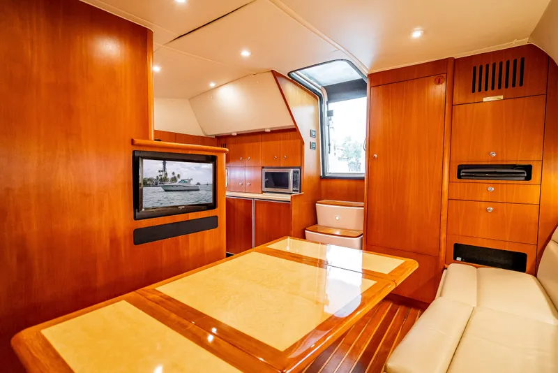 Slide: The Image of 2005 Tiara Yachts 4200 Open interior with wood finish, dining table, and modern amenities. - 14