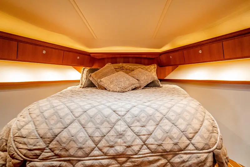Slide: The Image of Luxurious cabin interior of 2005 Tiara Yachts 4200 Open with cozy bedding and ambient lighting. - 15