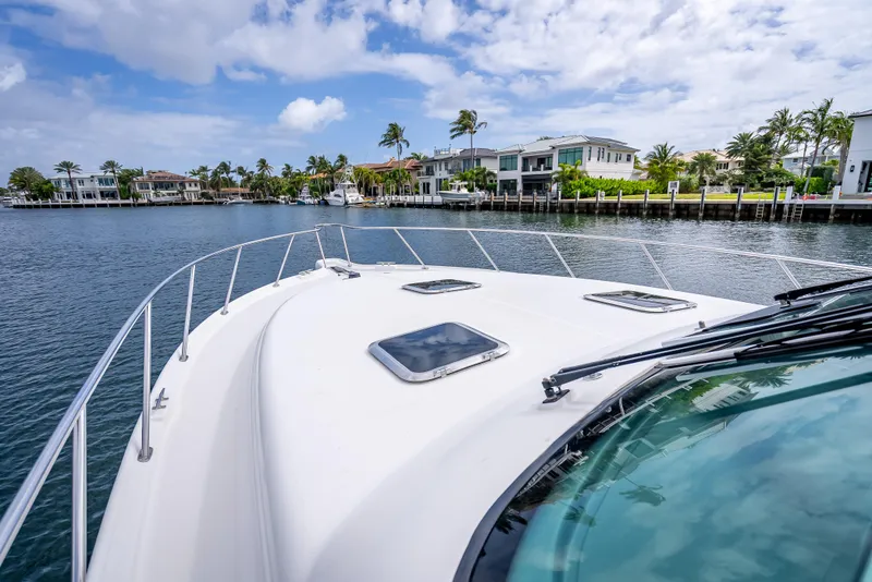 Slide: The Image of 2005 Tiara Yachts 4200 Open cruising near waterfront homes under a partly cloudy sky. - 3