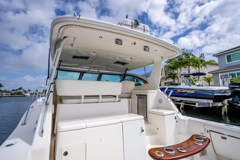 Slide: The Image of 2005 Tiara Yachts 4200 Open, spacious deck view, docked under a partly cloudy sky. - 44